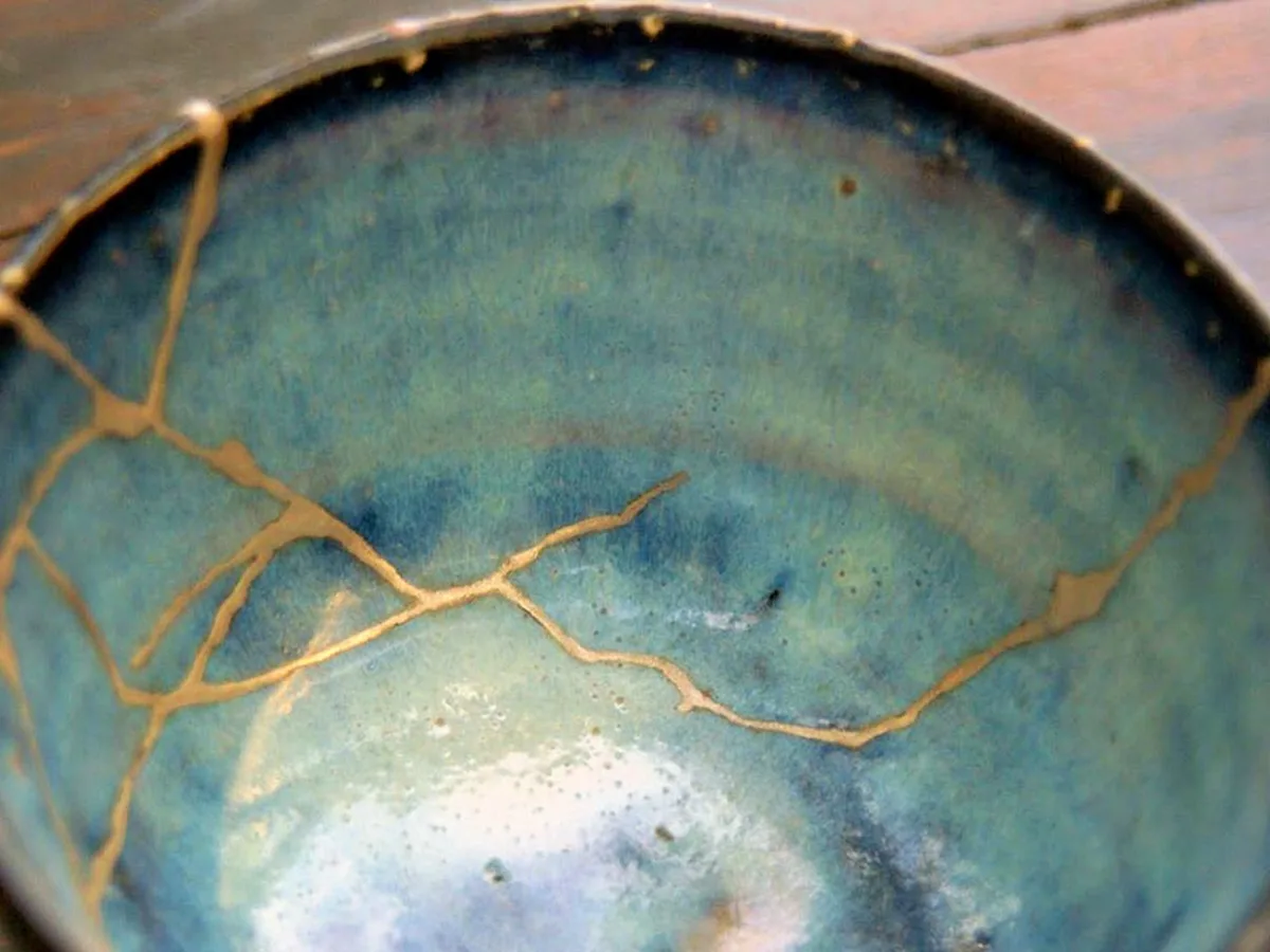 A blue ceramic bowl repaired with veins of gold — Kintsugi