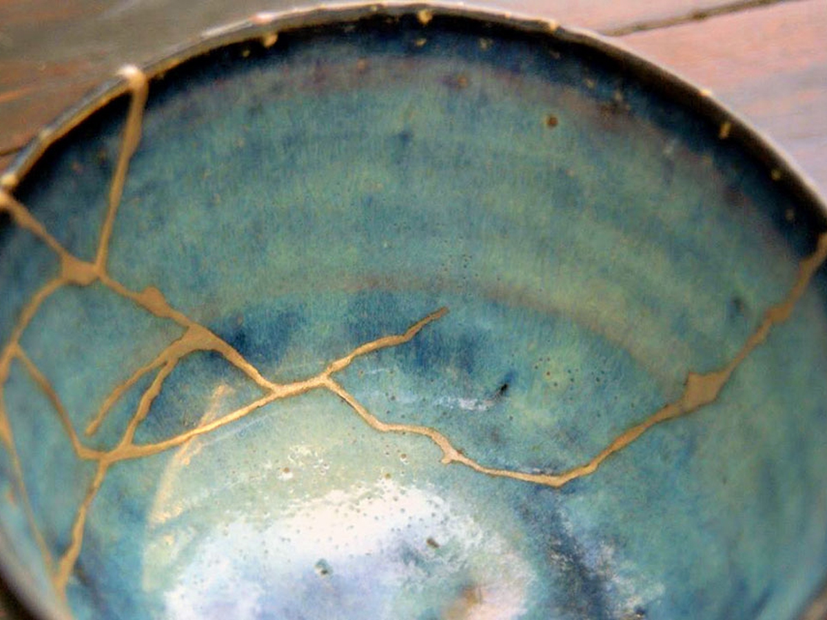 A blue ceramic bowl repaired with veins of gold — Kintsugi